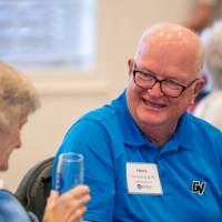 Two alumni laughing together.